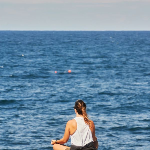 A serene woman practicing breathing exercises outdoors in nature.